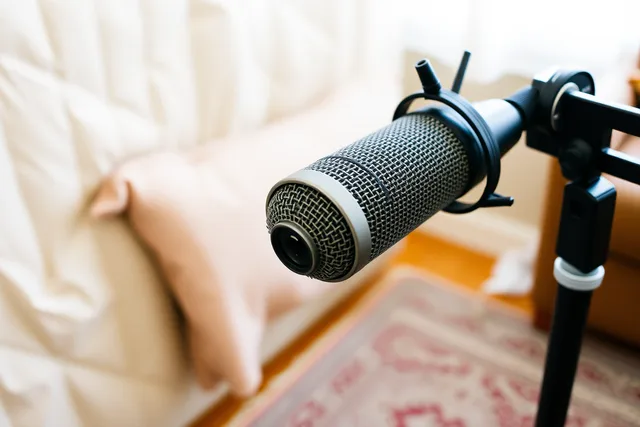 Dynamic podcast microphone on a boom arm in a treated home studio. Best budget podcast microphone UK: named USB and XLR models compared